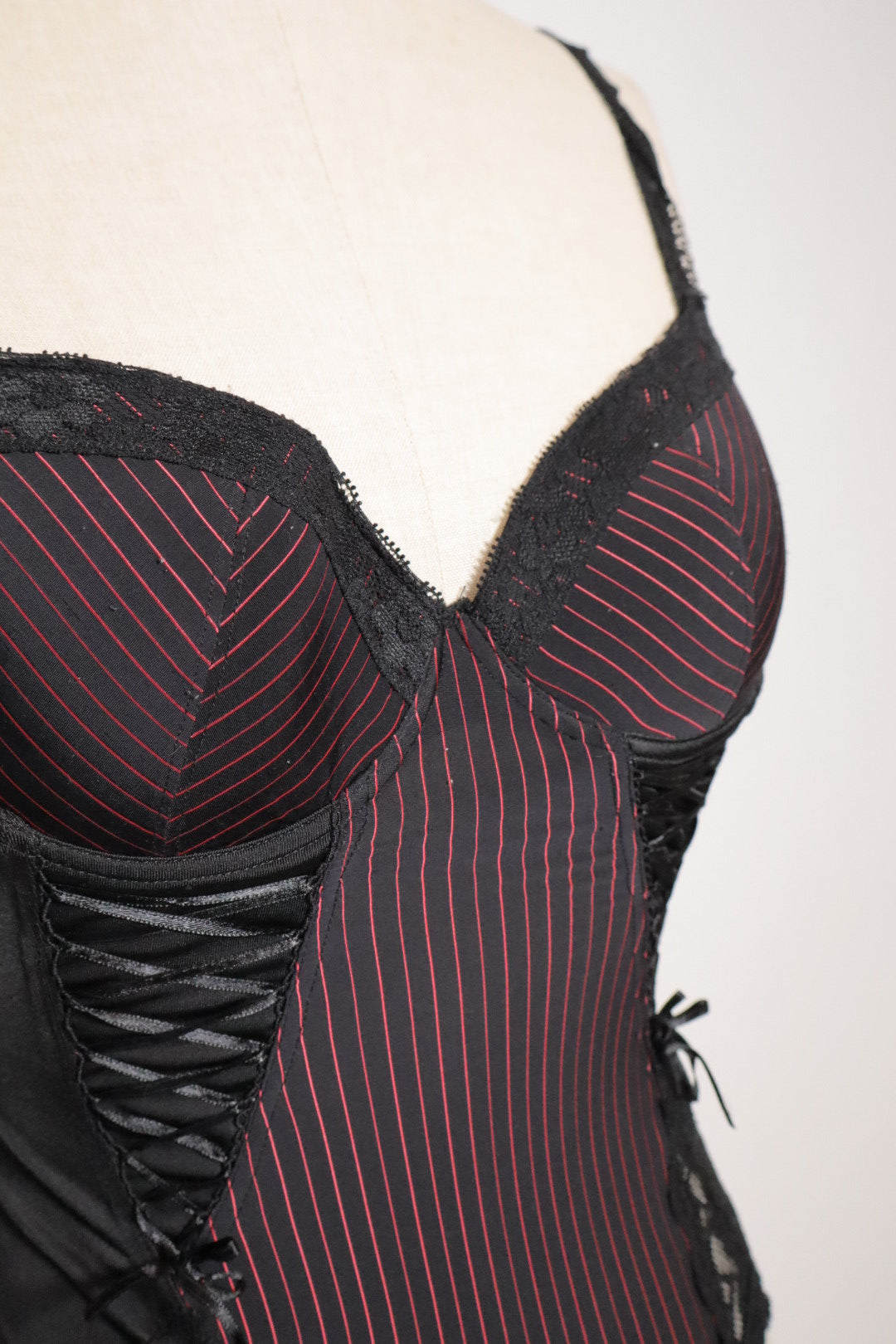 Black bustier with red stripes, open back and corset details on the sides