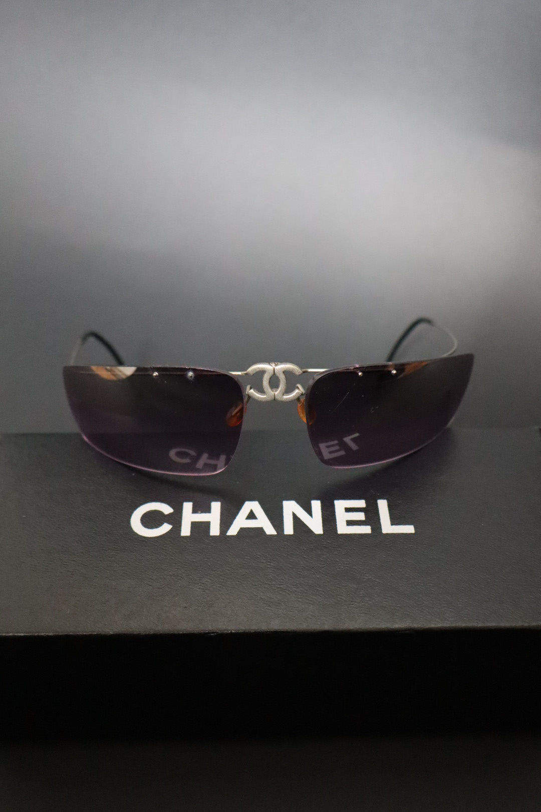 Chanel CC logo folding rimless wrap sunglasses with purple lenses