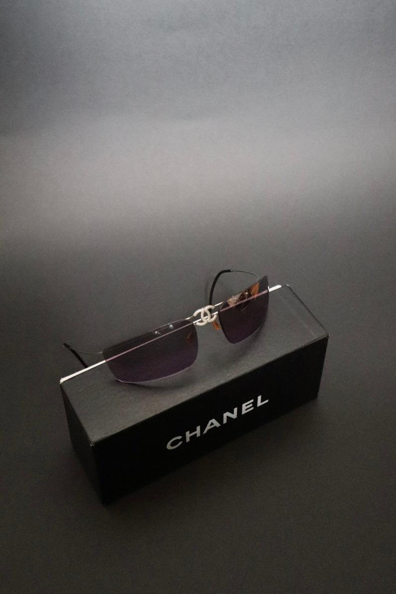 Chanel CC logo folding rimless wrap sunglasses with purple lenses
